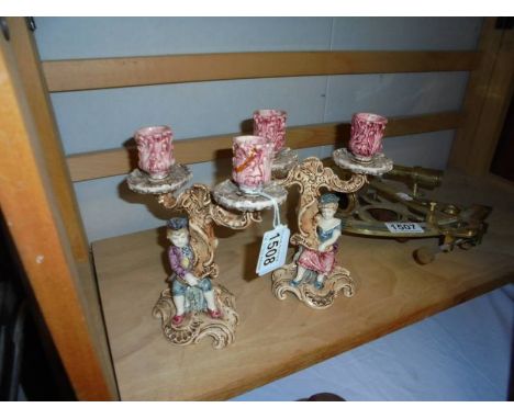 A pair of continental ceramic figural candlesticks.