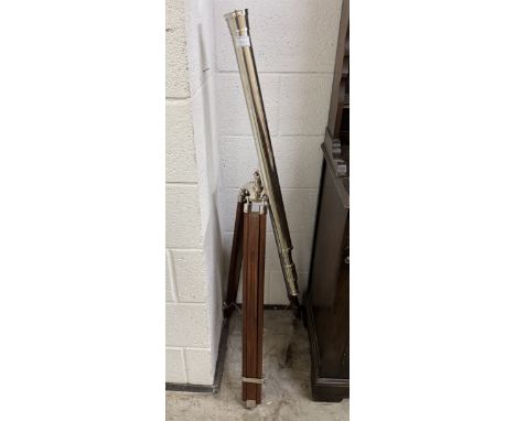A large chrome plated telescope on a teak tripod base.