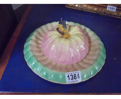 A vintage ceramic butter/cheese dish with lily pad base and flower head top with butterfly knob.