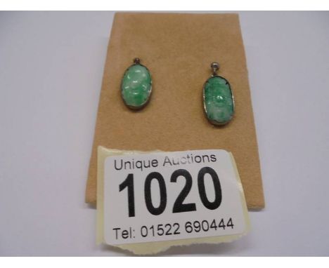 A pair of silver and jade pendant earrings.