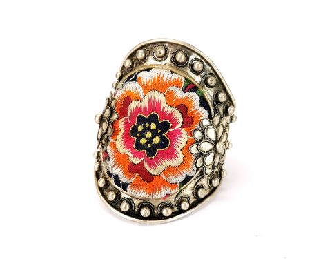 A Chinese white metal bangle inset with tribal embroidered fabric, top W. 9cm.