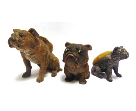 THREE WHITE METAL SEATED BULLDOGS  late 19th / early 20th century, comprising a cold painted pen wipe, 8cm high (two cracks t