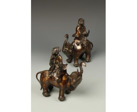 A PAIR OF CHINESE PARCEL-GILT BRONZE CENSERS, modelled as Immortals riding elephants, 8" high (2)