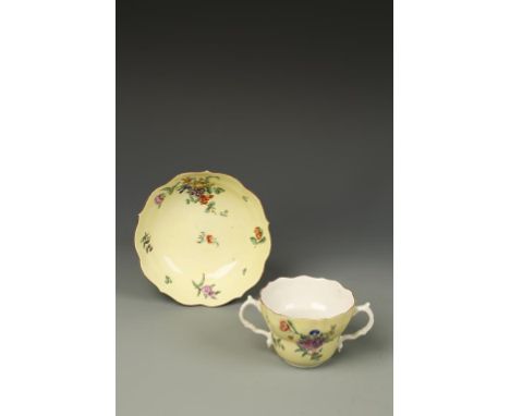 A WORCESTER PORCELAIN CHOCOLATE CUP AND SAUCER with polychrome painted flowers and leaves on a bright yellow ground, the sauc