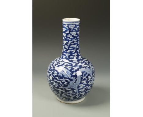 A CHINESE BLUE AND WHITE BOTTLE VASE decorated with two dragons, Kangxi mark, 19thC, 14" high