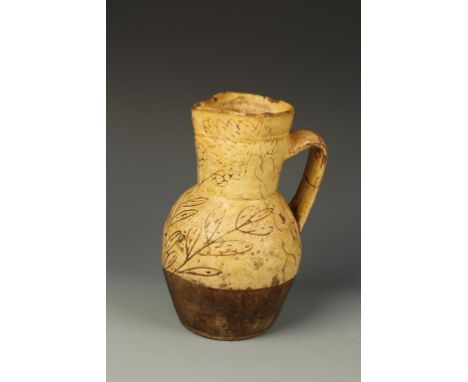 A BARNSTAPLE TYPE SLIPWARE JUG, decorated in light brown with incised floral decoration, 18th century, 9" high