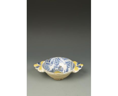 A DELFTWARE BOWL, with blue and yellow decoration, and two handles, 9.25" wide