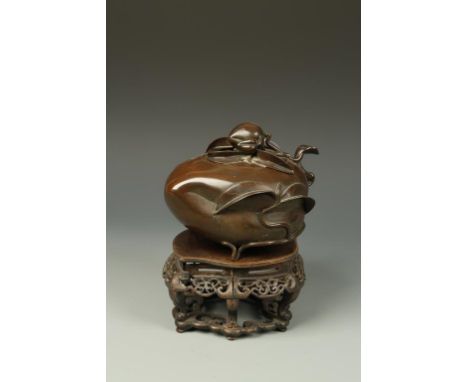 A CHINESE BRONZE PEACH-FORM CENSER, on a pierced hardwood stand, Qing, 18th/19thC, 7.5" long