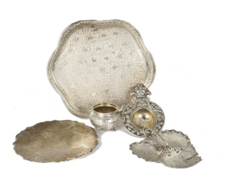 A vintage Indian silver tray, flower head shaped with ornate designs, together with a white metal tea strainer on stand with 