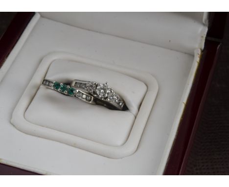 A modern 14ct white gold and diamond engagment ring and matching diamond and emerald wedding ring by Love Story, 6.2g and siz