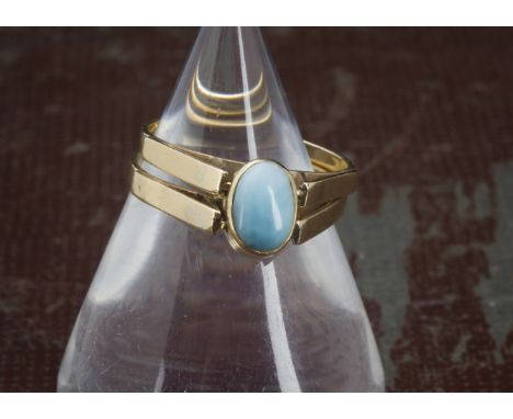 An African 14ct gold day and night ring, the two bands with hinged oval tablet having blue larimar stone to front and amber t