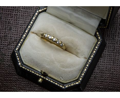 An 18ct gold and five stone diamond half hoop eternity ring, brilliant cuts on torsion settings, 3.2g and size N, one diamond