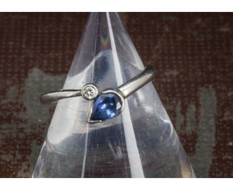 A modern platinum diamond and sapphire ring, with pear shaped blue sapphire and a brilliant cut in stylish mount, 3.4g and si