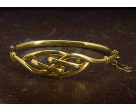 An Edwardian 9ct gold bangle, with knot style tablet, 7.3cm 