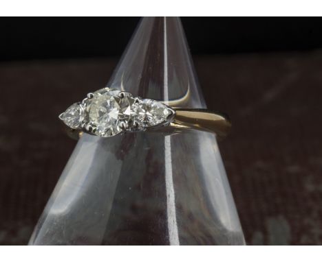 A pretty diamond engagement ring, haivng a modern round brilliant cut of 0.8ct flanked by a pair of pear shaped stones each 0