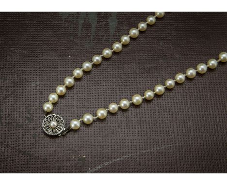A single strand pearl necklace, uniform white cultured pearls with sterling silver clasp 