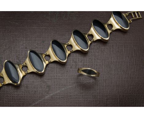 A modern 9ct gold and black onyx bracelet and ring, the elongated black panels in seven gold links, with similar ring, 56g (2