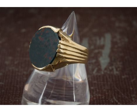 A vintage Middle Eastern gold and bloodstone gentleman's signet ring, the large oval panel in mount marked 21k, 11.2g and siz