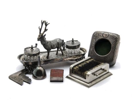 An Edwardian silver and leatherette pocket watch stand, together with a Victorian silver plated inkwell stand with stag, a pe