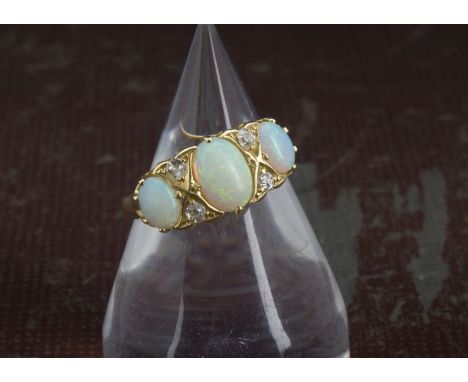 A Victorian 18ct gold opal and diamond ring, having three oval opals and four old cut stones, hallmarked Birmingham 1897, 5.6