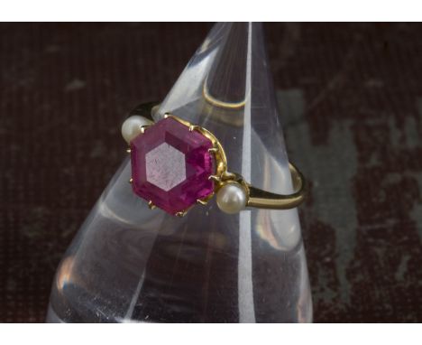 A vintage pink tourmaline and pearl dress ring, the hexagonal cut stone with small white pearl to each side in mount marked 1