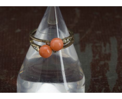 A vintage gold coral and seed pearl ring, crossover style mount with two pink coral beads, 1.8g, one bead loose 