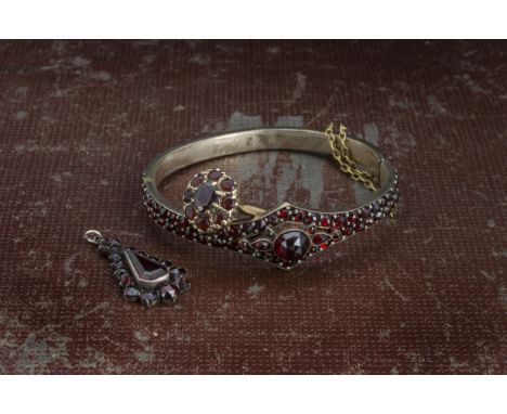 A Victorian silver gilt and garnet bangle, together with a 9ct gold and garnet cluster ring and a garnet pendant (3) 