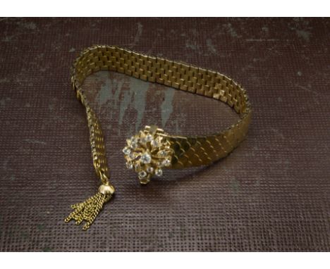 A retro Middle Eastern gold and white sapphire bracelet, the band of fish scale style links with tassel to end and having hin
