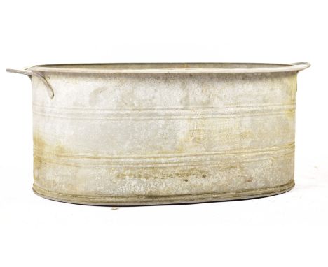 An early 20th century large oval galvanised tin bath / planter. The bath of oval form, with handles to either side. Measures 