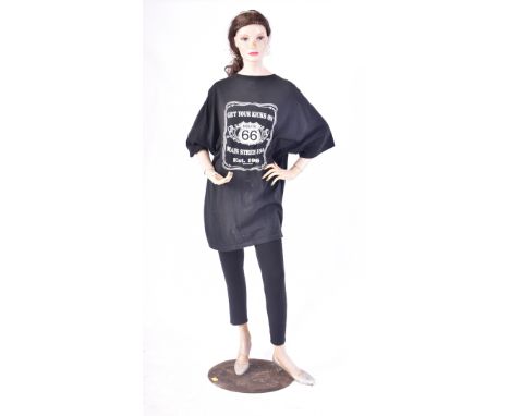 A vintage mid 20th century full body female shop display mannequin. The mannequin having articulated arms and legs raised on 