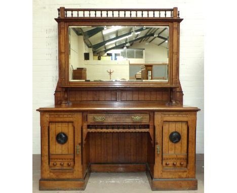 A late Victorian ebony strung pollard oak twin pedestal sideboard of aesthetic design, with each door having an applied round