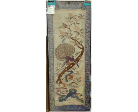 A 19th century Chinese woven silk tapestry panel depicting a peacock and other faunae in a naturalistic setting, with later p