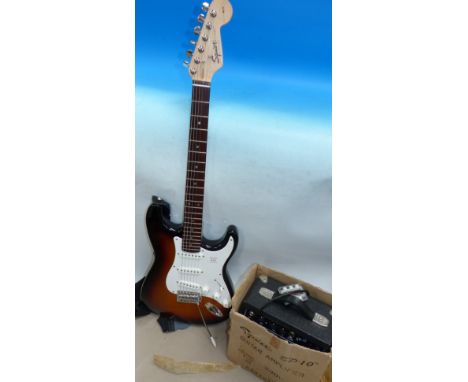 A Squier Strat by Fender electric guitar with a Squier amplifier