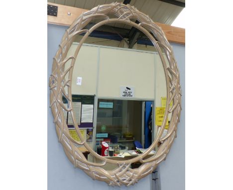 An oval mirror with decorative pierced frame