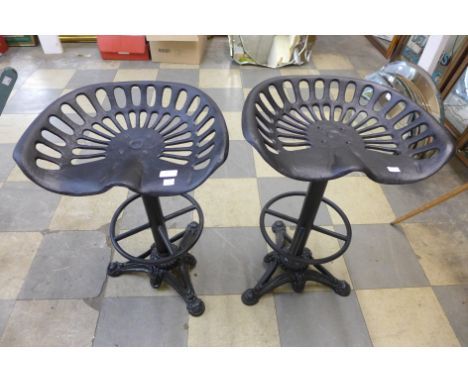 A pair of cast iron tractor seat stools 