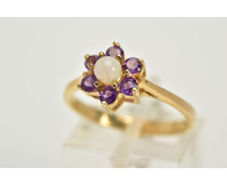 A 9CT GOLD OPAL AND AMETHYST CLUSTER RING, designed with a central opal cabochon, within a circular cut amethyst surround, ta