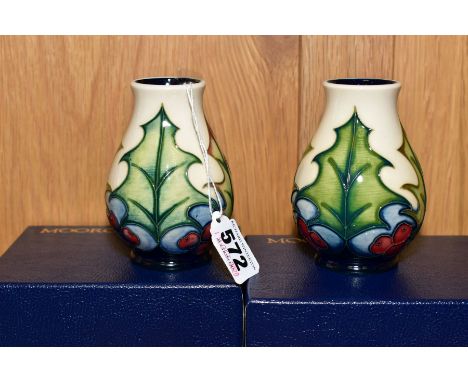 A PAIR OF MOORCROFT BALUSTER VASES, decorated in a Holly design on a cream ground, both signed to the bases in gold pen by Ph