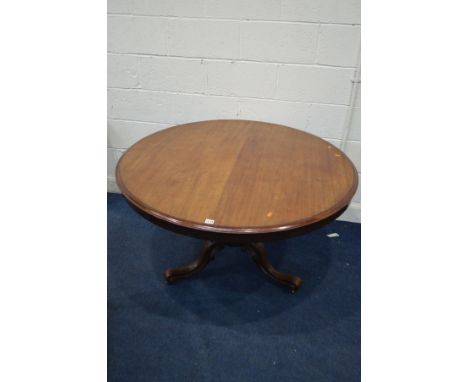 A VICTORIAN MAHOGANY CIRCULAR TILT TOP BREAKFAST TABLE on a bulbous support with tripod scrolled legs and ceramic casters
