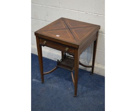 AN EDWARDIAN MAHOGANY AND STRUNG ENVELOPE CARD TABLE, with a single drawer, on square tapering legs united by stretchers to a