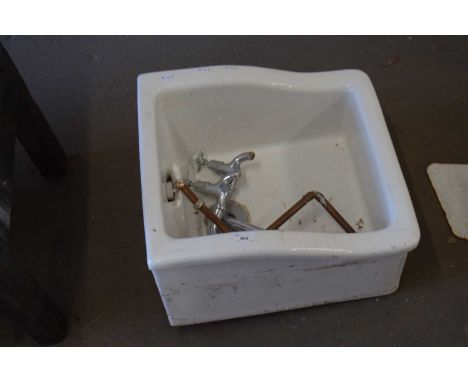 A small ceramic sink or basin with taps