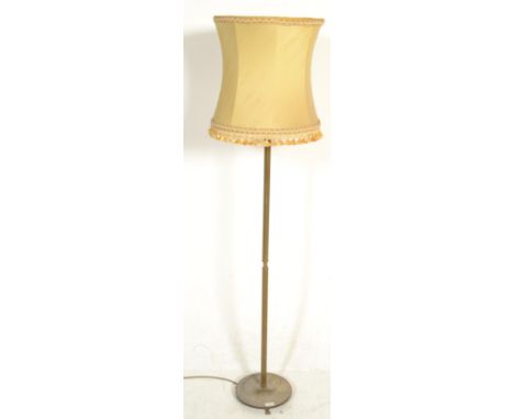 A 20th Century brass standard lamp being raised on a round base with three lions paw feet, with a central reeded column havin