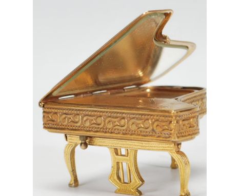 A vintage mid 20th Century ladies Pygmalion compact in the form of a piano, having articulated folding legs with mirror to th