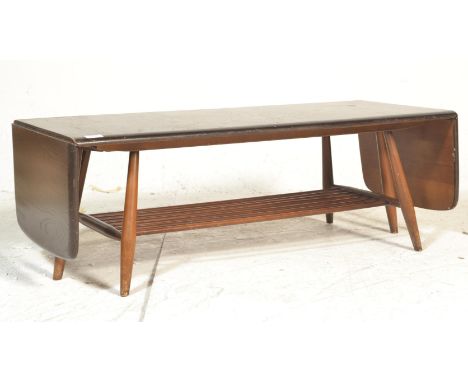 A 20th century Ercol beech and elm extending coffee table, rectangular top with two drop leaves having pull out action suppor