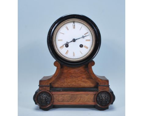 A late 19th Century French walnut cased mantel clock, fitted with barrel movement, the white enamel dial with Roman numerals,