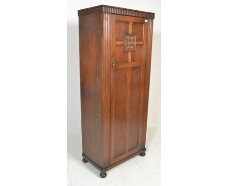 A 20th Century oak bachelors sentry box wardrobe in the manner of Jaycee / Old Charm, single panel door with carved central m