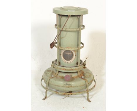 A vintage retro 20th Century metal&nbsp;paraffin heater by Aladdin of cylindrical form raised on a round base with carrying h