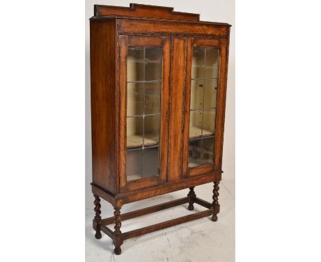 A 1920's oak barley twist shipping oak twin door bookcase / china display cabinet. Raised on barley twist legs united by stre