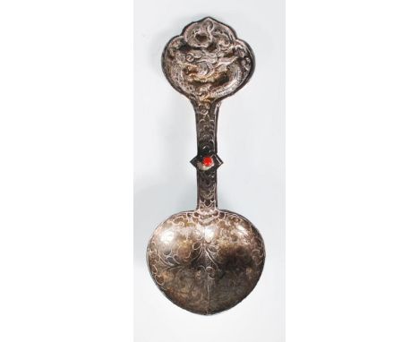 A late 19th / early 20th Century Chinese silver spoon having repousse dragon decorated handle with red stone cabochon to the 