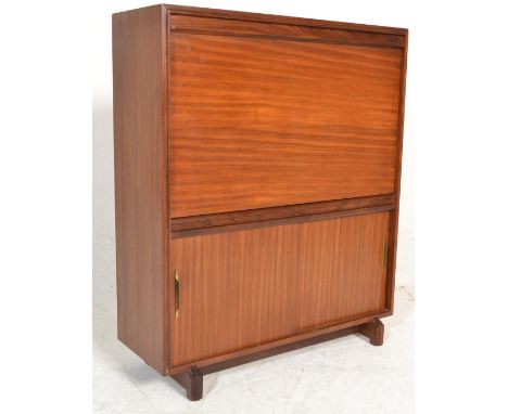 A 1970's retro vintage teak wood bureau by Beaver & Tapley having a drop down door top above a twin sliding door cupboard rai