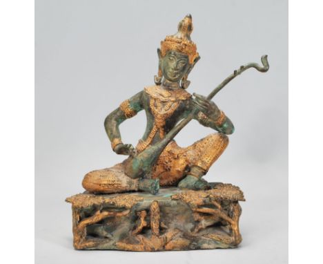 A 20th Century&nbsp;Indian brass&nbsp;figure of Saraswati the Hindu deity, modelled playing the sitar raised on a naturalisti